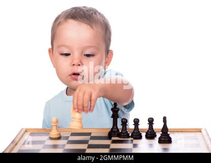 little boy staring at the chess pieces isolated on white background Stock Photo