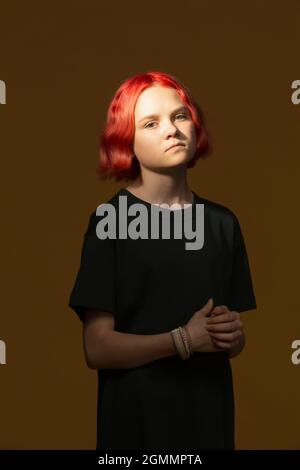 Portrait confident serious teenage girl with dyed red hair Stock Photo