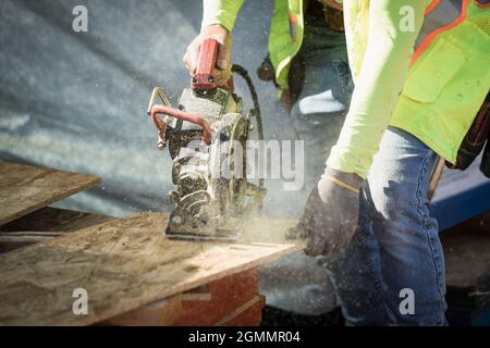 Construction worker using saw on plywood Stock Photo