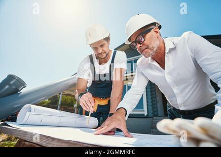 Construction workers are checking building layout outdoor Stock Photo