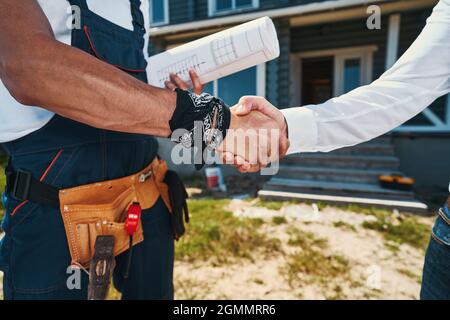 Engineers agreeing on construction plan with handshake Stock Photo