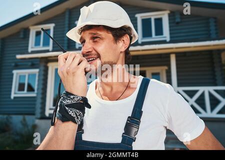 Builder giving information to another worker using walkie talkie Stock Photo