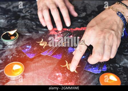 Show fortune tellers of hands holding tarot cards and tarot reader with candle light on the table, Performing readings magical performances, Things my Stock Photo