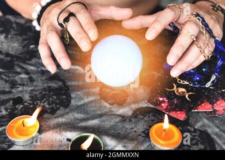 Show fortune tellers of hands holding tarot cards and tarot reader with candle light and magic Crystal ball, Performing readings magical performances, Stock Photo