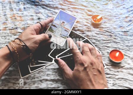 Show fortune tellers of hands holding tarot cards and tarot reader with candle light on the table, Performing readings magical performances, Things my Stock Photo