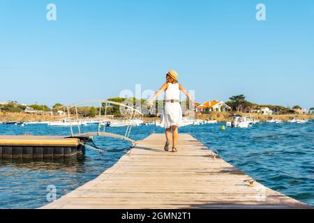 Young woman on vacation on the wooden pier in Cadaques, Spain Stock Photo