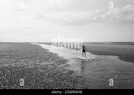 Twelve year old boy skim boarding at West Wittering Beach, Chichester, West Sussex, England, United Kingdom, England, United Kingdom. Stock Photo