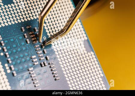 production of central processing units, tweezers working over a a cpu. Stock Photo