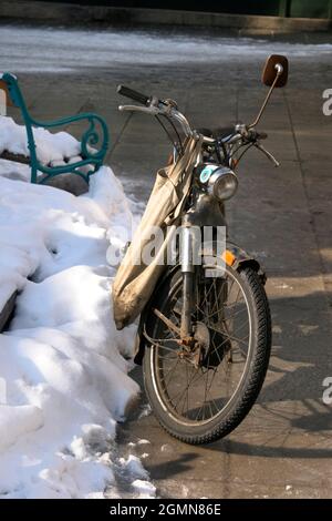 old motorcycle with a shopping bag in winter, Austria Stock Photo
