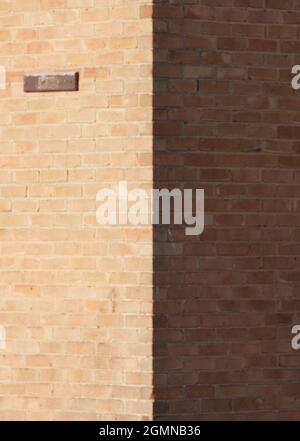 Close up of corner of a house wall, one part in shade, the other in sunlight. Stock Photo