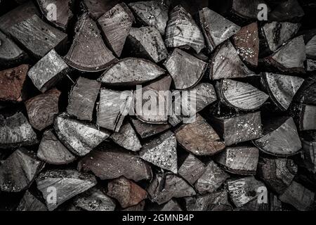 Dry oak firewood stacked in a pile, chopped wood for winter heating of the fireplace. Natural wood background. In winter, it will be warm and cozy. Th Stock Photo