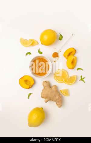 Ingredients of ginger tea with turmeric, fresh lemon and mint on a white background. Natural vitamin drink that protects health from viruses. Stock Photo
