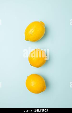 Ripe yellow lemons on blue background with copy space for your text. Top view. Flat lay pattern, banner. Frame made of fresh lemons Stock Photo