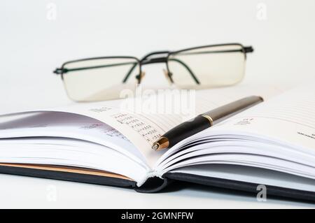 Diary, glasses and pen on white background. Business concept Stock Photo