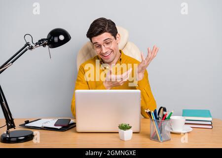Portrait of attractive cheery focused man talking web cam contact interview isolated over grey color background Stock Photo