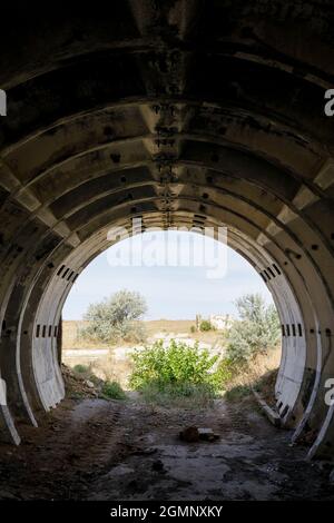 View from an abandoned concrete hangar dug into a hill. Remnants of the Cold War. Stock Photo