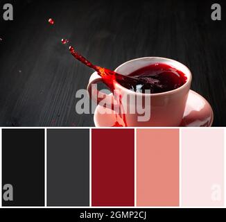 Color matching palette and cup of tea with splash on wooden background Stock Photo