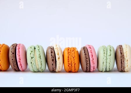 Different multicolor macarons on black stone plate Stock Photo