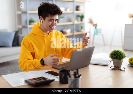 Asian man having video call using laptop and talking Stock Photo