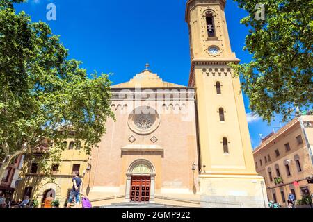 Barcelona, Spain - July 7, 2017: day view of Plaça de la Concòrdia and Església de Santa Maria del Remei with locals on benches in Barcelona, Spain. Stock Photo