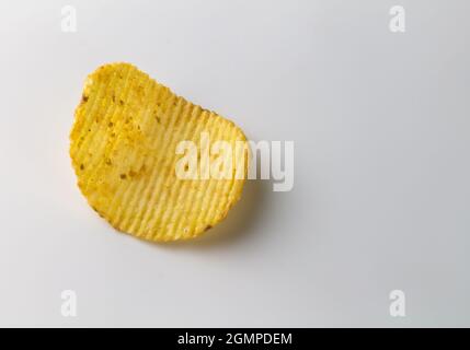 Single salty spicy potato crinkle cut chip isolated on white background with copy space Stock Photo