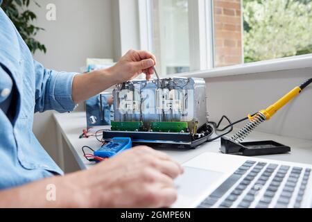 Close Up Of Man Fixing Electric Toaster Using Online Instructions Rather Than Buying New Product Sustainable Lifestyle Stock Photo