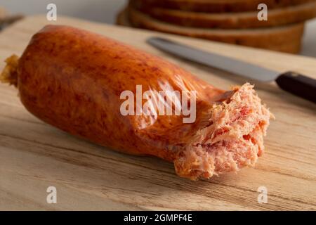 Single traditional German grob Teewurst, coarsely ground sausage, open in plastic close up Stock Photo