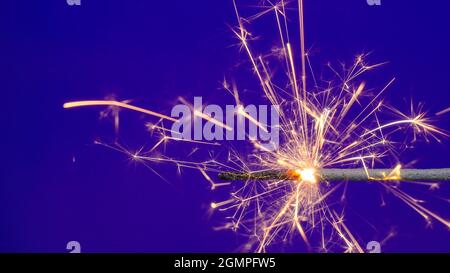 Burning bengal fire on blue background Stock Photo