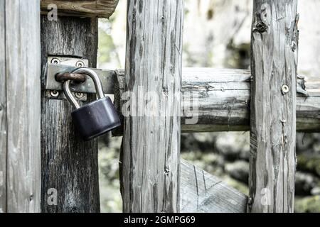 The padlock locked on a gate in a wooden fence. Stock Photo