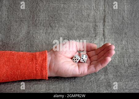 White dices on the male palm, close up. Board games. Stock Photo