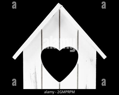front view of miniatur wooden house with heart shape inside isolated on black background, concept of sweet home with copy space Stock Photo