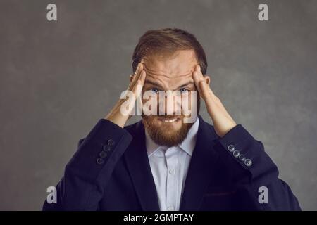Young man stressed and worried about making mistakes and creating problems at work Stock Photo