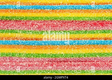 Background of rainbow sour jelly candies strips in sugar sprinkle. Top view, copy space Stock Photo