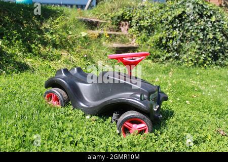https://l450v.alamy.com/450v/2gmr10m/a-black-bobbycar-stands-on-the-lawn-and-is-overgrown-2gmr10m.jpg