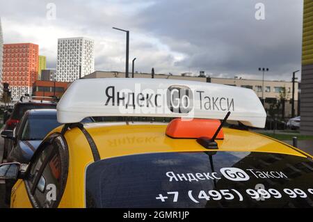 Yandex Taxi on the background of the city. Identification lights on the roof of the car with a logo. Close-up Stock Photo