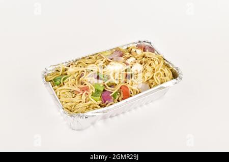 Veg Noodels in foil container on white background, take away food Stock Photo