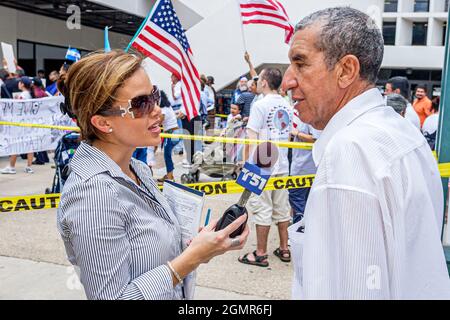 Miami Florida,Government Center centre,immigration rights protest,Hispanic man male,woman female journalist reporter media microphone interviewing Stock Photo