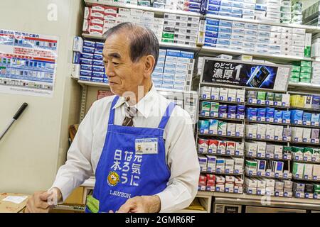 Tokyo Japan,Shinjuku,Lawson Convenience Store,shop market store business  display sale,Asian man male cashier clerk cigarettes cartons Japanese Stock  Photo
