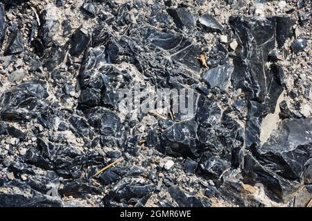 broken obsidian or volcanic glass on the ground Stock Photo