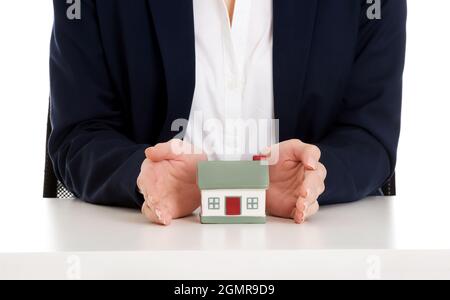 Closeup shot of the realtor showing a small house model Stock Photo