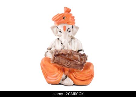 Indian god Ganesh playing dholak isolated on white background with clipping path, lord Ganesh Stock Photo