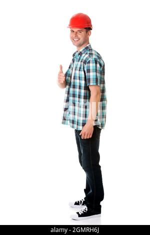 Portrait of a young happy engineer in a helmet showing a big thumb Stock Photo