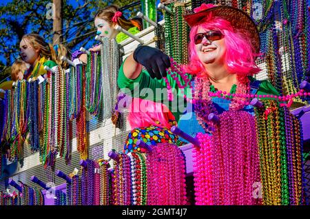 A woman throws Mardi Gras beads during the Joe Cain Day Mardi Gras parade, Feb. 7, 2016, in Mobile, Alabama. Stock Photo