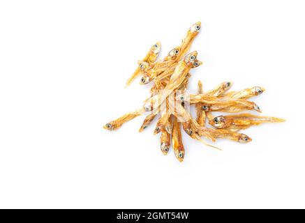 Top view small group of dried anchovies fish on white background, macro image, isolated dried crispy anchovies fish with golden brown color. Stock Photo