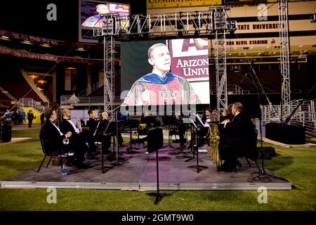 Symphonic band members watch the video monitor as President Barack Obama speaks before the 2009 Arizona State University commencement ceremony in Tempe, Arizona, May, 13 2009. (Official White House Photo by Chuck Kennedy) This official White House photograph is being made available for publication by news organizations and/or for personal use printing by the subject(s) of the photograph. The photograph may not be manipulated in any way or used in materials, advertisements, products, or promotions that in any way suggest approval or endorsement of the President, the First Family, or the White H Stock Photo