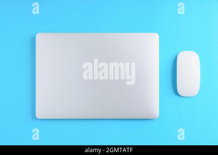 laptop computer and mouse on blue background above view Stock Photo
