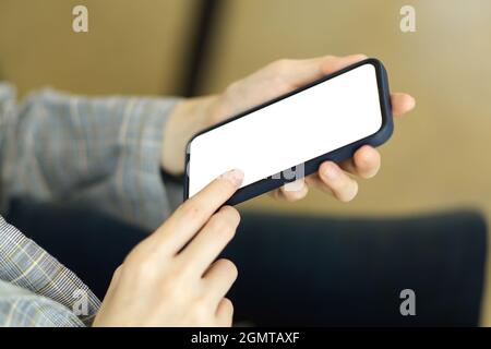 Mobile phone white screen mockup on female hands with blurred background Stock Photo