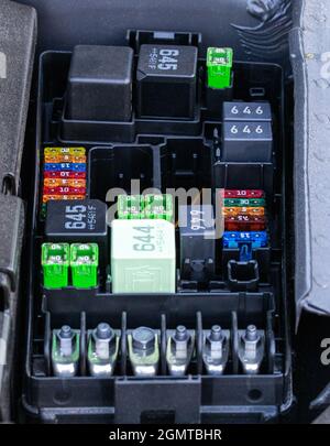 Plastic fuse box inside the engine compartment, visible fuses, relays
