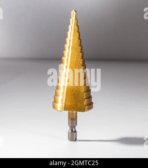 Gold step drill for drilling holes of different diameters, close-up Stock Photo