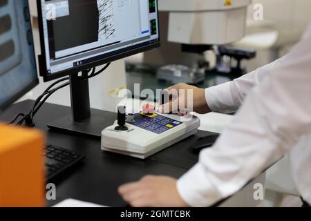 Quality test of a workpiece with vision measuring system. Selective focus. Stock Photo